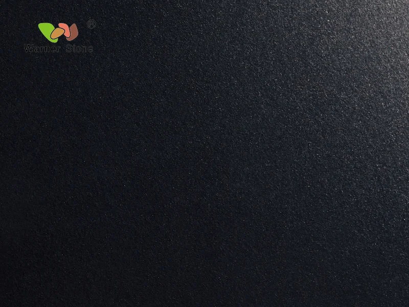 a black surface with a green leaf on it
